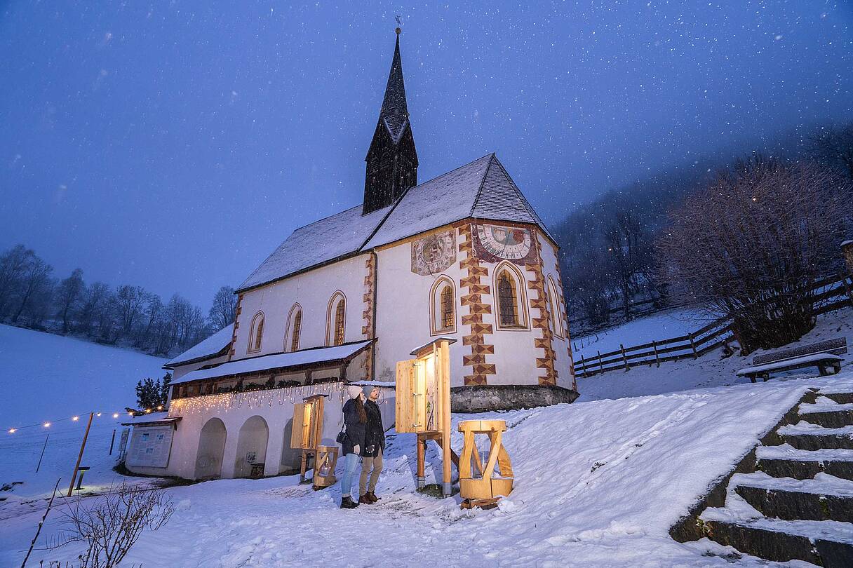 Beleuchtete, verschneite Kirche in Bad Kleinkirchheim in der Nacht